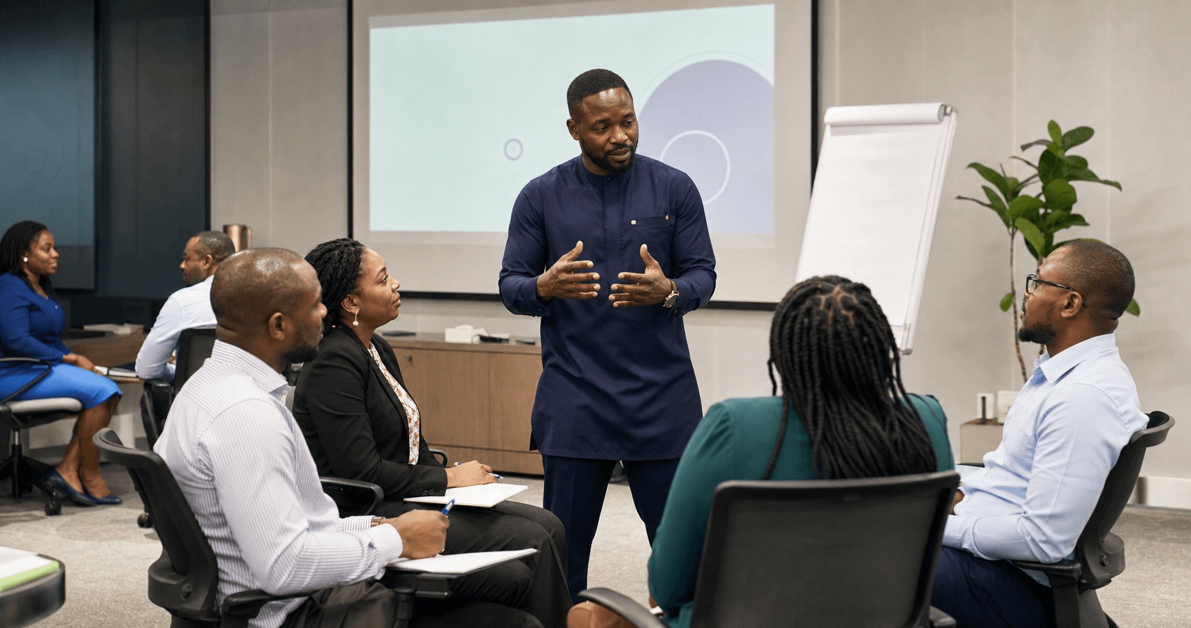 Black Nigerian facilitator leading an onsite professional training session